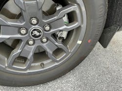 Example of a tire mounted. This tire features only a red dot, with no yellow dot. The wheel features a sticker indicating the wheel low point. The tire is mounted to align the red dot (highest point of radial runout) to this sticker.